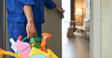 unrecognizable-cleaner-walking-into-hotel-room-with-tools-detergents_11zon